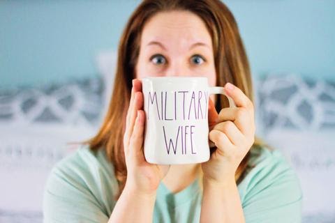 A woman holding a mug with text.