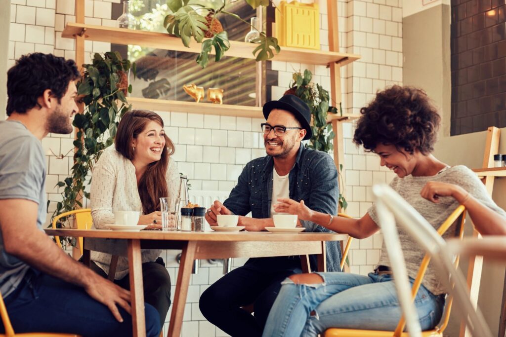 A group of people sitting at tables in a restaurant.