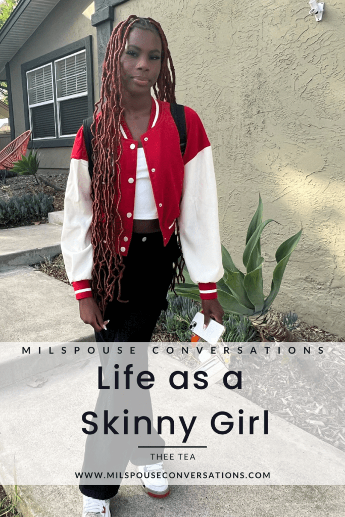 A girl in red and white jacket standing outside.