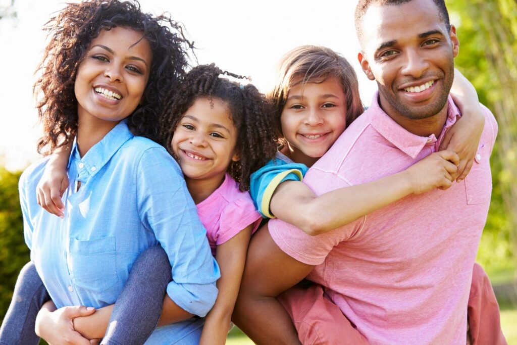 A family of four sitting on the ground.