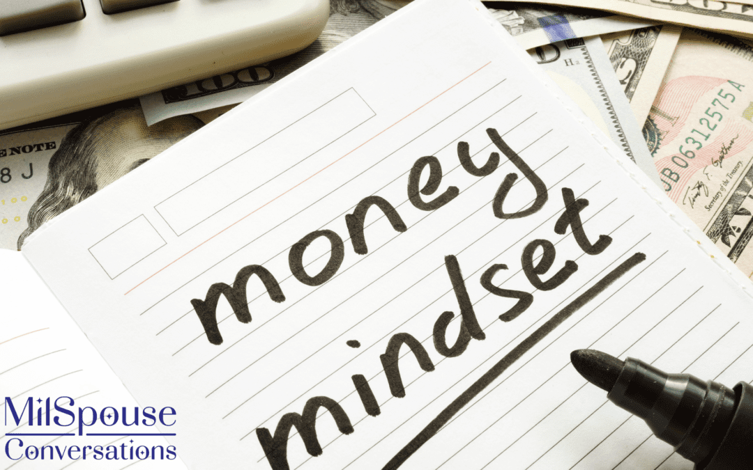 A notebook with the words money mindset sitting on top of a pile of money.